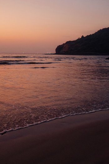 View of a tranquil beach where the gentle waves kiss the shore under a sky painted with soft hues of pink and orange at dusk Chiplun Maharashtra India. View of a tranquil beach where the gentle waves kiss the shore under a sky painted with soft hues of pink and orange at dusk Chiplun Maharashtra India.