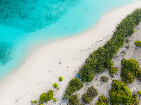 Aerial view of a white sand beach and vivid turquoise sea bordered by lush green vegetation Hoarafushi Thiladhunmathee Uthuruburi Maldives. Aerial view of a white sand beach and vivid turquoise sea bordered by lush green vegetation Hoarafushi Thiladhunmathee Uthuruburi Maldives.