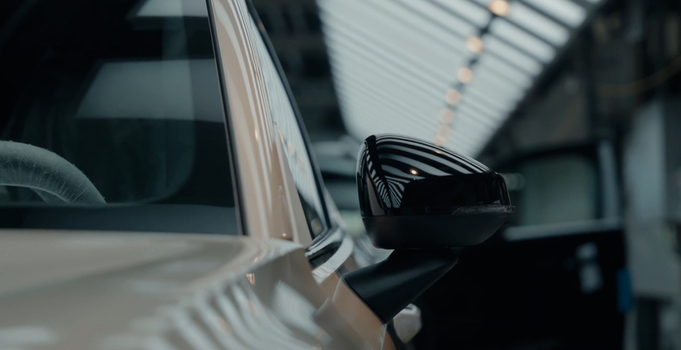 View of a car side mirror in an automotive factory with robotic assembly lines in the background in Hiroshima Hiroshima Japan. View of a car side mirror in an automotive factory with robotic assembly lines in the background in Hiroshima Hiroshima Japan.