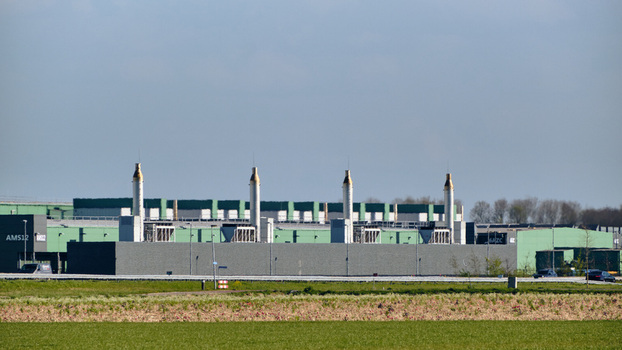 View of the Microsoft Datacenter AMS 12 Campus with its distinctive exhaust stacks and green facade under a clear sky in Middenmeer North Holland Netherlands.