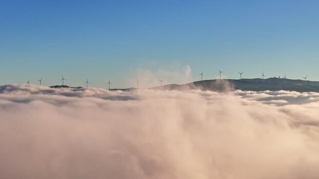 Aerial view of wind turbines above clouds in Austria.