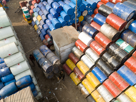 Aerial view of stacks of colorful industrial barrels in a storage yard with workers moving containers Dhaka Dhaka Division Bangladesh. Aerial view of stacks of colorful industrial barrels in a storage yard with workers moving containers Dhaka Dhaka Division Bangladesh.
