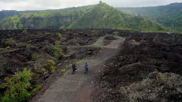 Aerial view of motorbikes riding through Batur volcano lava field Indonesia.