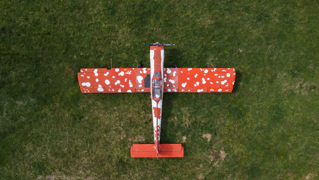 Serbia 11 April 2021 Aerial view of a small airplane with a distinctive red and white polka dot pattern parked on a green grassy field. Serbia 11 April 2021 Aerial view of a small airplane with a distinctive red and white polka dot pattern parked on a green grassy field.
