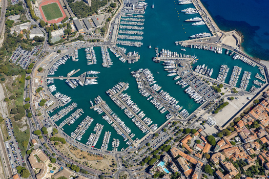 Aerial view of Port Vauban in Antibes featuring numerous luxury yachts and sailboats docked in the marina surrounded by urban infrastructure in Antibes Provence Alpes Cote d Azur France. Aerial view of Port Vauban in Antibes featuring numerous luxury yachts and sailboats docked in the marina surrounded by urban infrastructure in Antibes Provence Alpes Cote d Azur France.