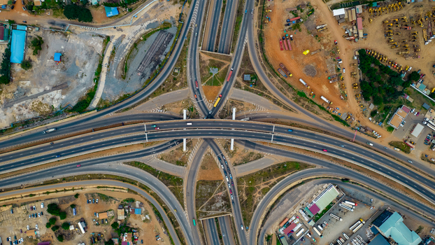 Aerial view of the Tema Motorway interchange featuring multi level highway ramps asphalt roads and surrounding urban infrastructure in Accra Greater Accra Region Ghana. Aerial view of the Tema Motorway interchange featuring multi level highway ramps asphalt roads and surrounding urban infrastructure in Accra Greater Accra Region Ghana.