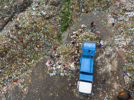 Aminbazar Bangladesh 26 January 2025 Aerial view of the Aminbazar landfill with a blue garbage truck and workers sorting through vast piles of colorful plastic waste and trash. Aminbazar Bangladesh 26 January 2025 Aerial view of the Aminbazar landfill with a blue garbage truck and workers sorting through vast piles of colorful plastic waste and trash.