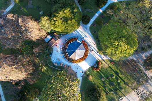 Aerial view of the octagonal pavilion in Parc de l Independance surrounded by blooming tulip beds lush green trees and people walking on paths in Morges Vaud Switzerland. Aerial view of the octagonal pavilion in Parc de l Independance surrounded by blooming tulip beds lush green trees and people walking on paths in Morges Vaud Switzerland.