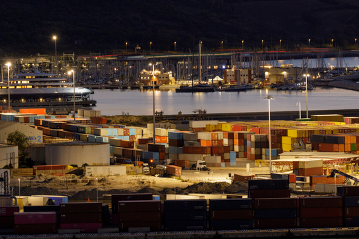 Aerial view of Ancona Port at night featuring rows of colorful shipping containers illuminated harbor facilities and yachts docked in the marina in Ancona Marche Italy. Aerial view of Ancona Port at night featuring rows of colorful shipping containers illuminated harbor facilities and yachts docked in the marina in Ancona Marche Italy.