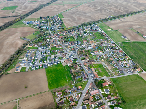 Aerial view of a quaint village nestled amidst the patchwork of agricultural fields a symphony of earthy browns and vibrant greens Neuf Brisach Grand Est France.