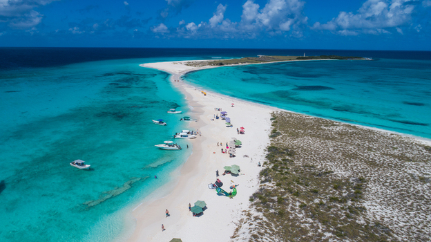 Aerial view of the Los Roques archipelago featuring turquoise waters white sand beaches anchored boats and people enjoying the sunny day in Los Roques Dependencias Federales Venezuela. Aerial view of the Los Roques archipelago featuring turquoise waters white sand beaches anchored boats and people enjoying the sunny day in Los Roques Dependencias Federales Venezuela.