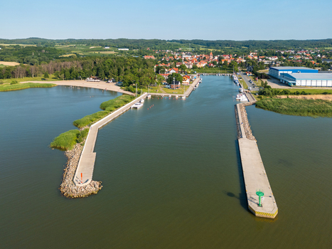 Aerial view of Port Tolkmicko featuring concrete breakwaters a marina with small boats and the historic town of Tolkmicko on the shore of the Vistula Lagoon in Warmia Masuria Poland. Aerial view of Port Tolkmicko featuring concrete breakwaters a marina with small boats and the historic town of Tolkmicko on the shore of the Vistula Lagoon in Warmia Masuria Poland.