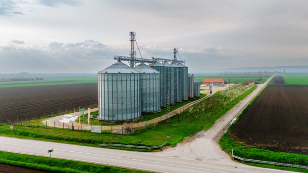Aerial view of gleaming silos stand tall amidst the checkerboard fields reflecting the soft light of the horizon Sremska Mitrovica Vojvodina Serbia. Aerial view of gleaming silos stand tall amidst the checkerboard fields reflecting the soft light of the horizon Sremska Mitrovica Vojvodina Serbia.