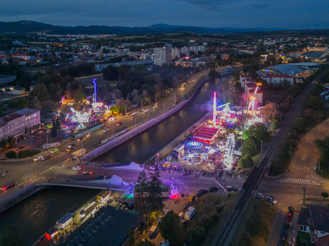 Aerial view of Radvansky jarmok with illuminated carnival rides and crowds along the river in the city at night Banska Bystrica Banskobystricky kraj Slovakia.