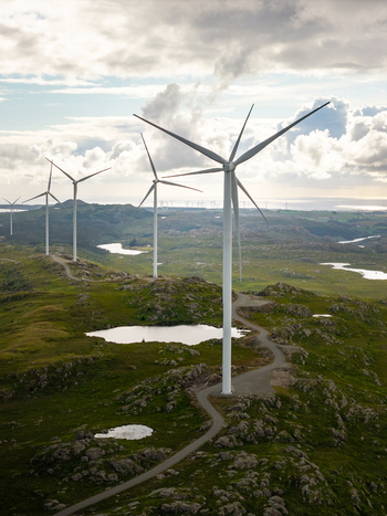 Aerial view of wind turbines at Makaknuten Wind Farm set in a rugged landscape with small lakes and green hills in Bjerkreim Municipality Rogaland Norway. Aerial view of wind turbines at Makaknuten Wind Farm set in a rugged landscape with small lakes and green hills in Bjerkreim Municipality Rogaland Norway.