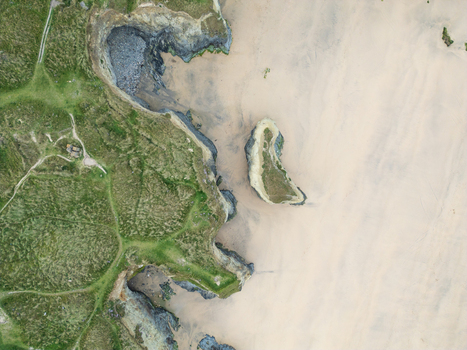 Aerial view of Godrevy Beach featuring sandy shores rugged rocky cliffs and green coastal paths in Gwithian England United Kingdom. Aerial view of Godrevy Beach featuring sandy shores rugged rocky cliffs and green coastal paths in Gwithian England United Kingdom.