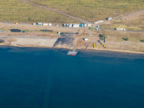 Aerial view of repair works on the floating solar system at Cottbuser Ostsee a former open pit mine with construction equipment and shoreline in Cottbus Brandenburg Germany. Aerial view of repair works on the floating solar system at Cottbuser Ostsee a former open pit mine with construction equipment and shoreline in Cottbus Brandenburg Germany.