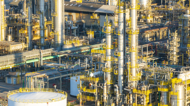 Aerial view of a large petrochemical complex featuring tall distillation columns intricate piping networks and storage tanks under warm sunlight in Santo Andre State of Sao Paulo Brazil.