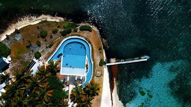 Aerial view of a resort swimming pool and turquoise coast Honduras. Aerial view of a resort swimming pool and turquoise coast Honduras.