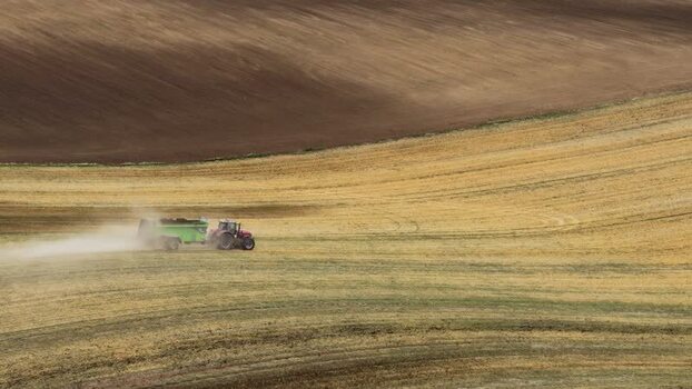 Aerial view of a tractor working on rolling fields Czechia.
