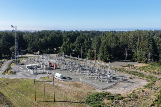 Aerial view of a power substation surrounded by dense evergreen forests and power lines in Bandon Oregon United States. Aerial view of a power substation surrounded by dense evergreen forests and power lines in Bandon Oregon United States.