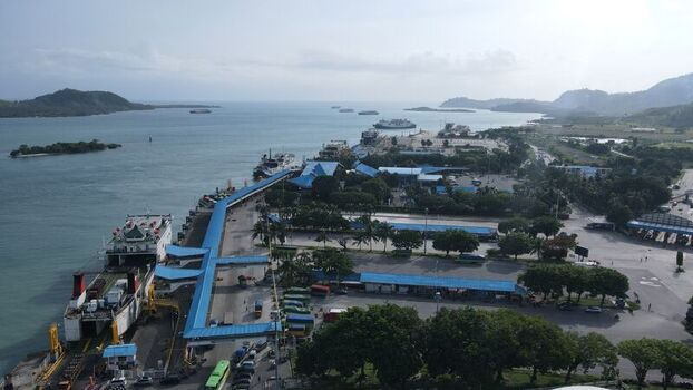 Bakauheni Lampung Indonesia 15 December 2021 Aerial view of Bakauheni ferry port with docked ships terminal buildings and parking areas along the coastline.