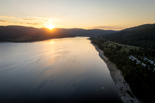 Aerial view of Schluchsee lake at sunset with golden light reflecting on the water surface and dark forested hills Schluchsee Baden Wurttemberg Germany. Aerial view of Schluchsee lake at sunset with golden light reflecting on the water surface and dark forested hills Schluchsee Baden Wurttemberg Germany.
