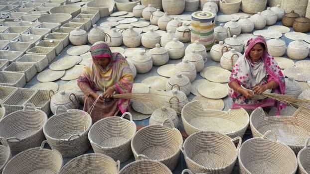 View of women weaving traditional baskets in Bogura Bangladesh. View of women weaving traditional baskets in Bogura Bangladesh.