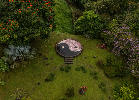Aerial view of a circular Yin Yang symbol set in a lush garden surrounded by tropical trees and flowering plants in Cinchona Alajuela Province Costa Rica. Aerial view of a circular Yin Yang symbol set in a lush garden surrounded by tropical trees and flowering plants in Cinchona Alajuela Province Costa Rica.