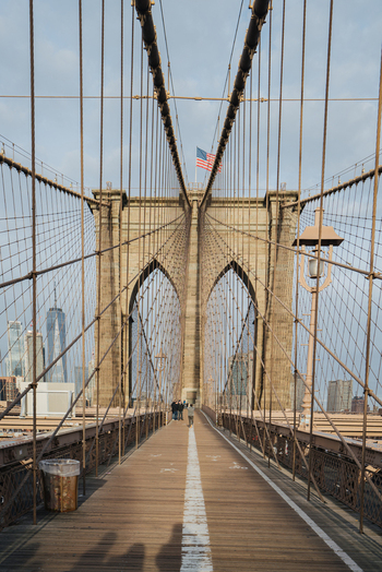 View of Brooklyn Bridge with its iconic stone arches suspension cables and the Manhattan skyline in the background New York New York United States.