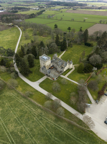 Aerial view of Drum Castle Garden and Estate National Trust for Scotland with its historic stone tower green lawns and winding paths Drumoak Scotland United Kingdom.