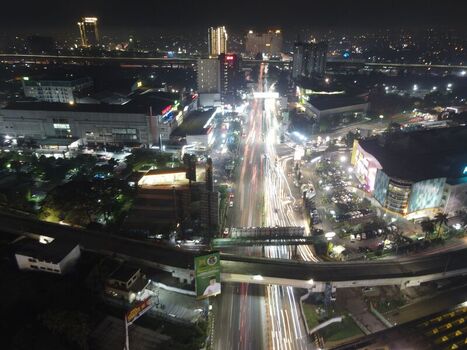 Aerial view of night cityscape with illuminated highways and light trails from heavy traffic flowing through the urban center of Bekasi Barat West Java Indonesia. Aerial view of night cityscape with illuminated highways and light trails from heavy traffic flowing through the urban center of Bekasi Barat West Java Indonesia.