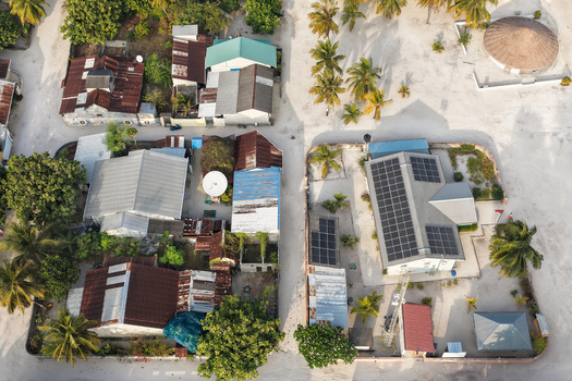 Aerial view of a lush tropical island with dense palm forests white sandy beaches and a vibrant coral reef in Vaikaradhoo Haa Dhaalu Atoll Maldives. Aerial view of a lush tropical island with dense palm forests white sandy beaches and a vibrant coral reef in Vaikaradhoo Haa Dhaalu Atoll Maldives.