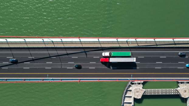 Aerial view of Alfred Zampa Memorial Bridge with trucks and cars driving on the asphalt road over green water in Vallejo California United States.