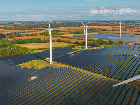 Aerial view of the Chelveston Renewable Energy site featuring wind turbines and extensive solar panel arrays set within the rural landscape of Chelveston England United Kingdom. Aerial view of the Chelveston Renewable Energy site featuring wind turbines and extensive solar panel arrays set within the rural landscape of Chelveston England United Kingdom.