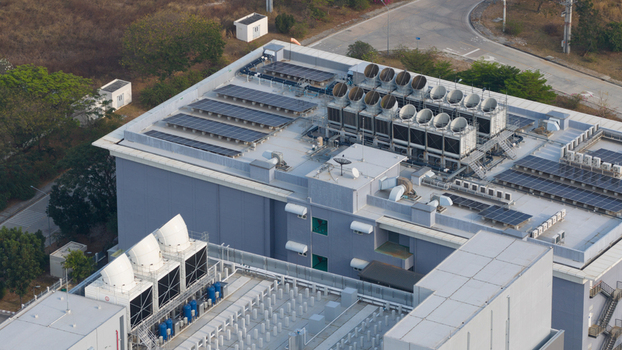 Aerial view of NTT Global Data Centers Thailand Limited featuring rooftop solar panels and industrial cooling towers in Tambon Don Huaro Chang Wat Chon Buri Thailand.