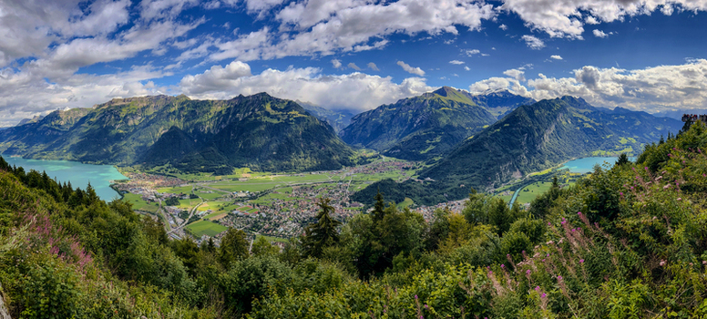 Aerial view of the town of Interlaken nestled between Lake Brienz and Lake Thun surrounded by the majestic Swiss Alps under a dramatic cloudy sky Interlaken Canton of Bern Switzerland.