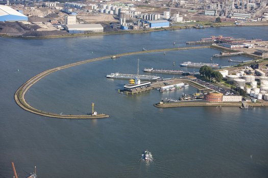 Rotterdam Netherlands 03 September 2014 Aerial view of Rotterdam Harbour featuring industrial infrastructure storage tanks and cargo ships navigating the waterway. Rotterdam Netherlands 03 September 2014 Aerial view of Rotterdam Harbour featuring industrial infrastructure storage tanks and cargo ships navigating the waterway.