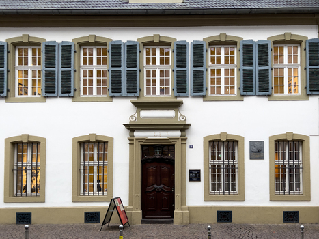 View of the Karl Marx House with its white facade dark wooden door grey shutters and barred windows in Trier Rheinland Pfalz Germany.
