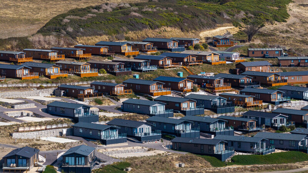 Aerial view of West Bay holiday park featuring numerous modern static caravans arranged on a hillside overlooking the coast in West Bay England United Kingdom. Aerial view of West Bay holiday park featuring numerous modern static caravans arranged on a hillside overlooking the coast in West Bay England United Kingdom.