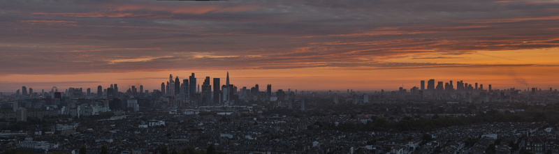 Aerial view of the London skyline at sunset featuring iconic skyscrapers and dense urban residential areas under a vibrant orange and purple sky in Wandsworth London United Kingdom.