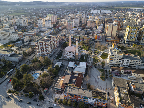 Aerial view of the Fier Mosque surrounded by urban residential buildings city squares and green spaces in the city of Fier Fier County Albania. Aerial view of the Fier Mosque surrounded by urban residential buildings city squares and green spaces in the city of Fier Fier County Albania.