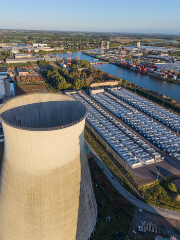 Aerial view of the Cargovil battery energy storage system and a large cooling tower situated in an industrial landscape near the canal in Vilvoorde Vlaanderen Belgium. Aerial view of the Cargovil battery energy storage system and a large cooling tower situated in an industrial landscape near the canal in Vilvoorde Vlaanderen Belgium.