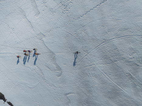 Aerial view of skiers trekking on the snow covered Versante sud dell Etna with long shadows and tracks Nicolosi Sicilia Italy. Aerial view of skiers trekking on the snow covered Versante sud dell Etna with long shadows and tracks Nicolosi Sicilia Italy.