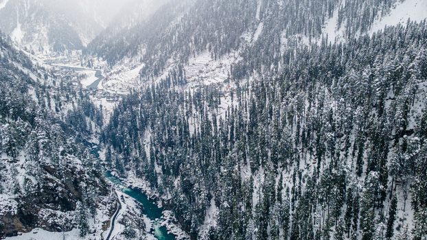 Aerial view of the dazzling contrast of the turquoise river cutting through the snow laden forest Sharda Azad Kashmir Pakistan. Aerial view of the dazzling contrast of the turquoise river cutting through the snow laden forest Sharda Azad Kashmir Pakistan.