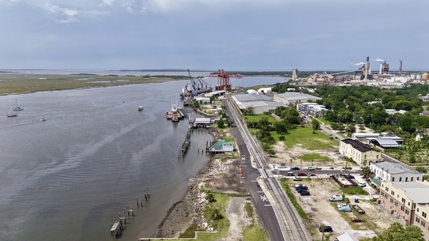 Aerial view of the Amelia River s murky waters contrast with the vibrant green of the shoreline near industrial structures and docks Fernandina Beach Florida United States. Aerial view of the Amelia River s murky waters contrast with the vibrant green of the shoreline near industrial structures and docks Fernandina Beach Florida United States.