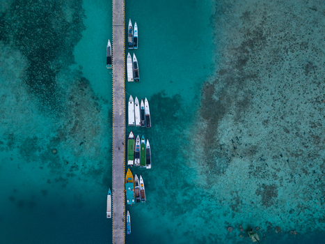 Aerial view of the Karimunjawa dockyard with various small boats moored along the concrete pier in the clear turquoise waters of the Java Sea Karimunjawa Jawa Tengah Indonesia. Aerial view of the Karimunjawa dockyard with various small boats moored along the concrete pier in the clear turquoise waters of the Java Sea Karimunjawa Jawa Tengah Indonesia.