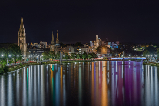 View of the Inverness city skyline at night with the illuminated St Andrew s Cathedral and Inverness Castle reflecting in the River Ness Inverness Scotland United Kingdom. View of the Inverness city skyline at night with the illuminated St Andrew s Cathedral and Inverness Castle reflecting in the River Ness Inverness Scotland United Kingdom.