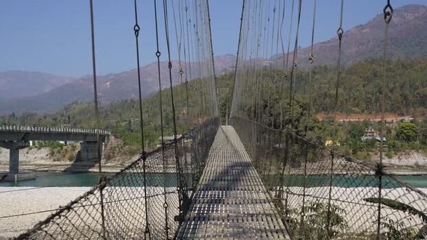 View of a long suspension bridge over a river Nepal.
