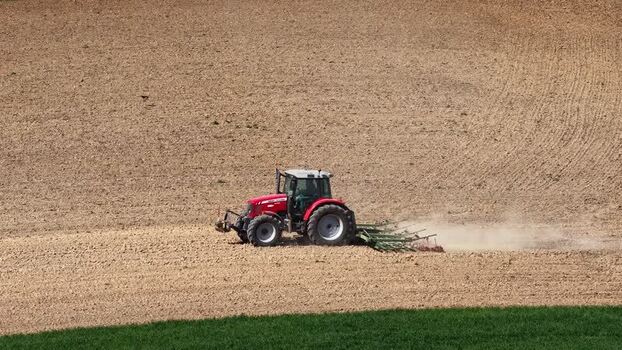 Aerial view of tractor plowing field France.